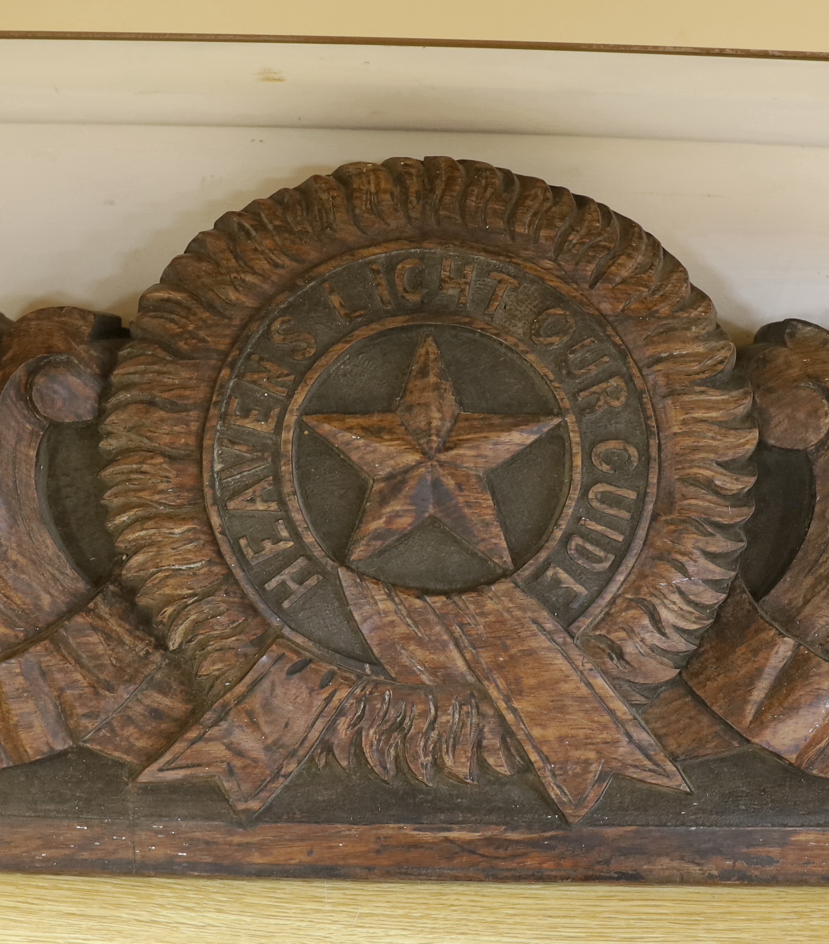 An Anglo-Indian carved hardwood panel with inscribed motto ‘Heavens Light Our Guide’, The motto for the order of the star of India, 123cm long